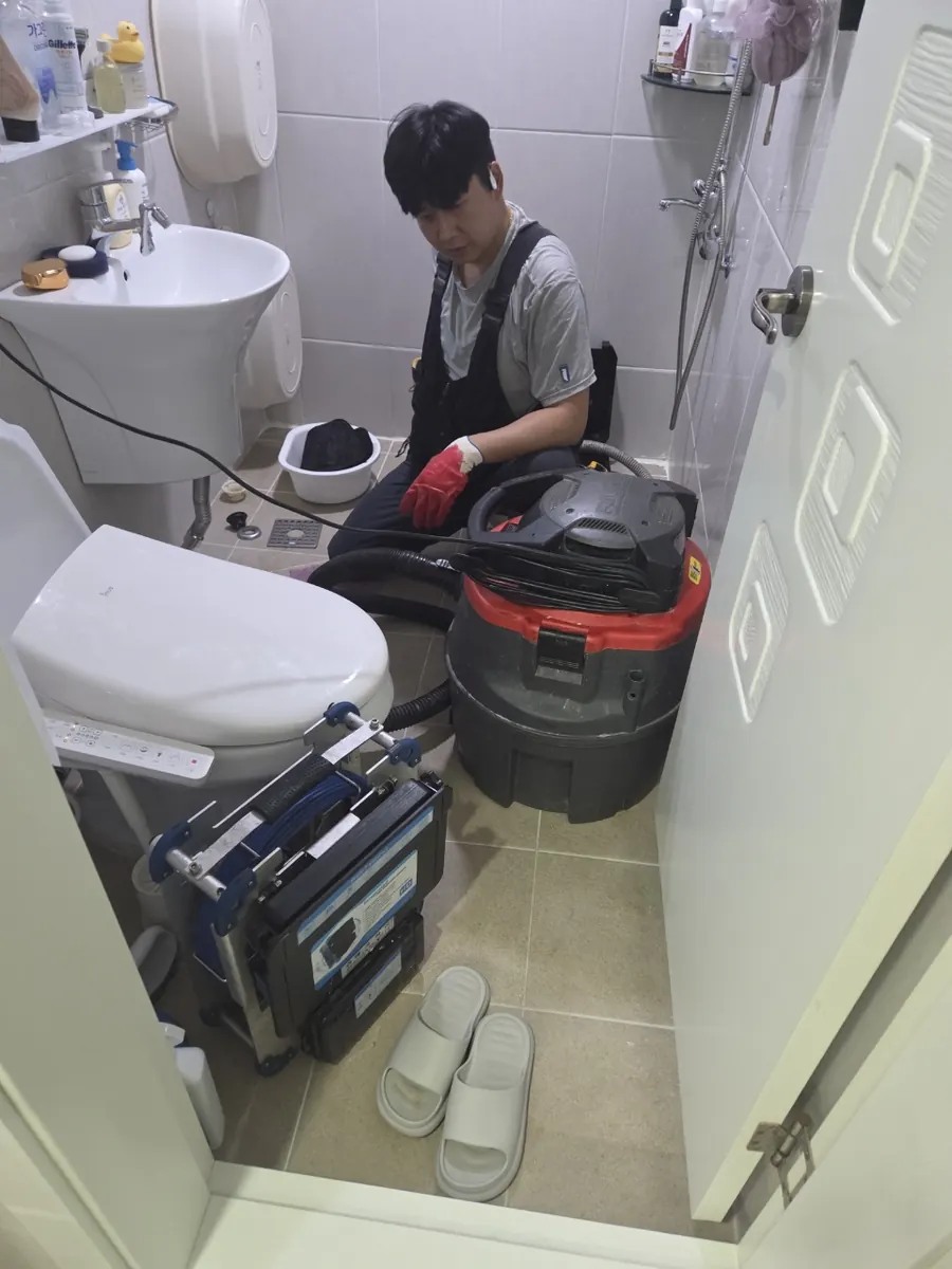 욕실에서 장비를 사용하는 작업자
